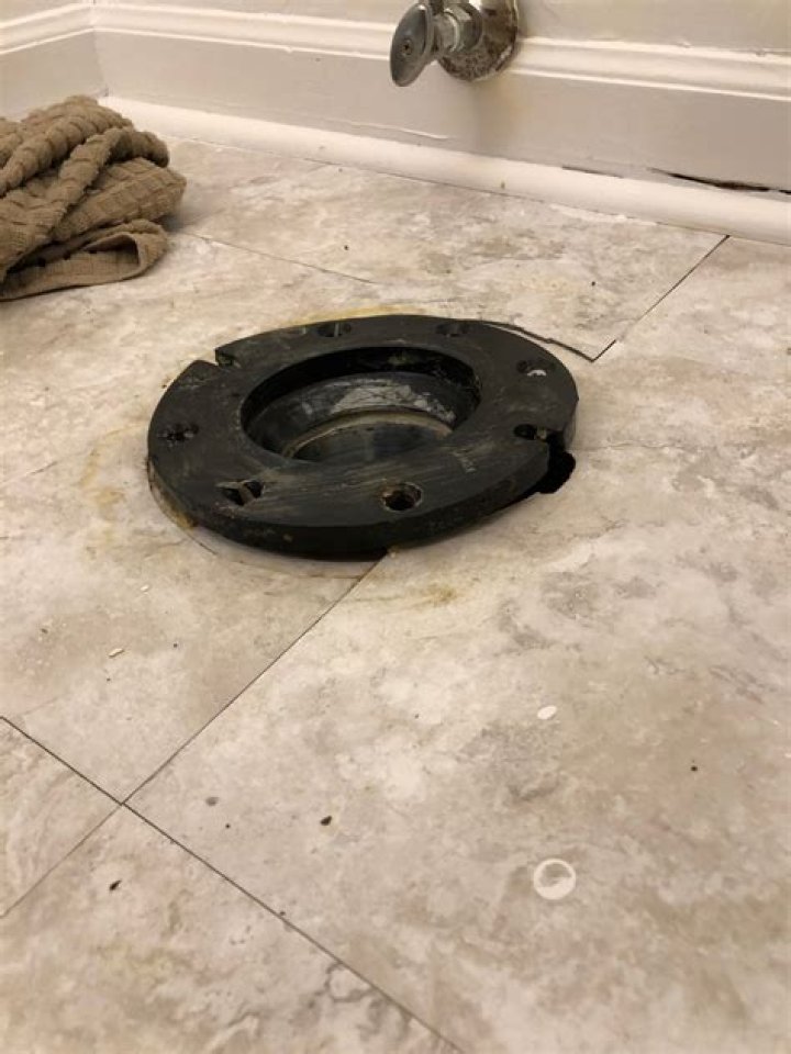Should toilet flange be screwed to floor?